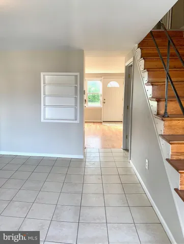 a hallway with a black white checkered floor next to a window