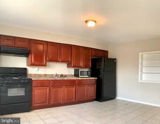 a kitchen with stainless steel appliances granite countertop a stove refrigerator and cabinets