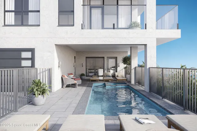 a living room with couches chandelier and a potted plant