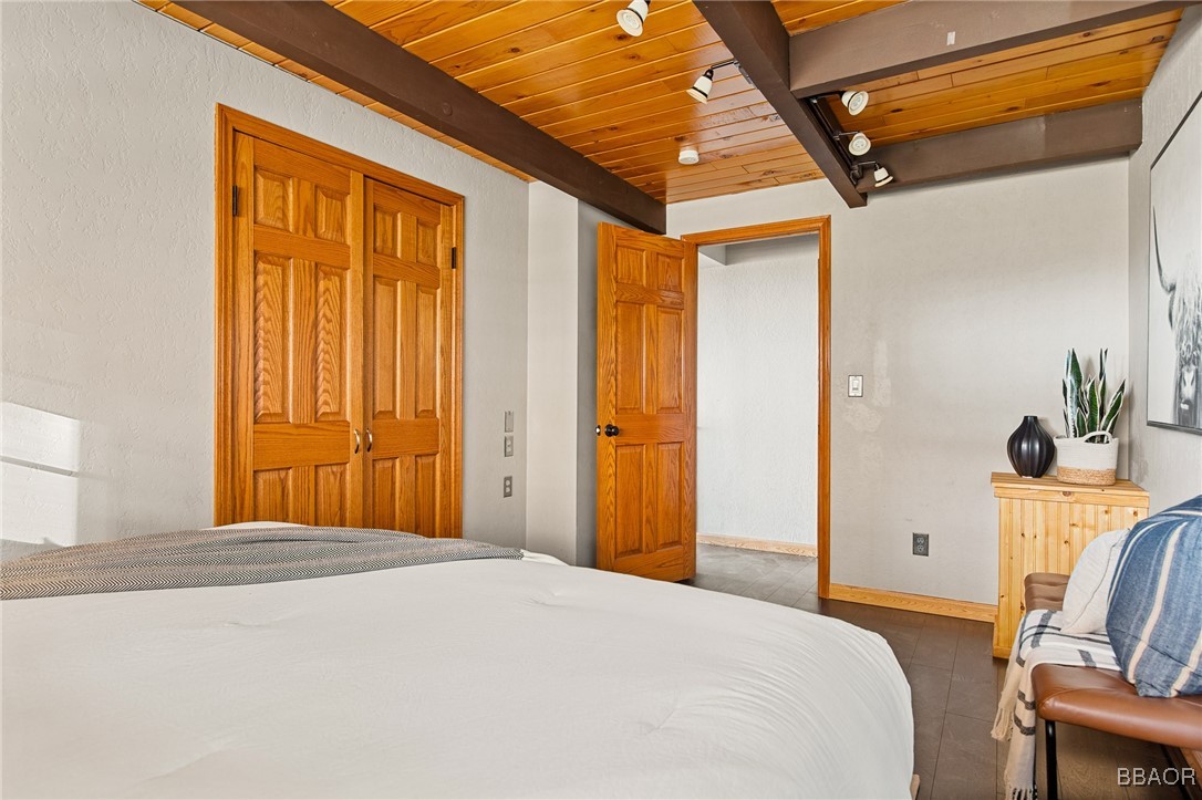 28971 Banff Drive Lake Arrowhead, CA 92352 - Photo 16 of 46 a bedroom with a bed and wooden floor