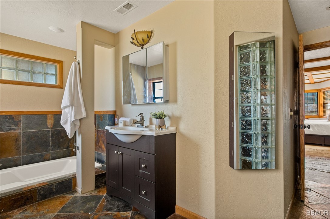 28971 Banff Drive Lake Arrowhead, CA 92352 - Photo 18 of 46 a bathroom with a sink a mirror and a bathtub