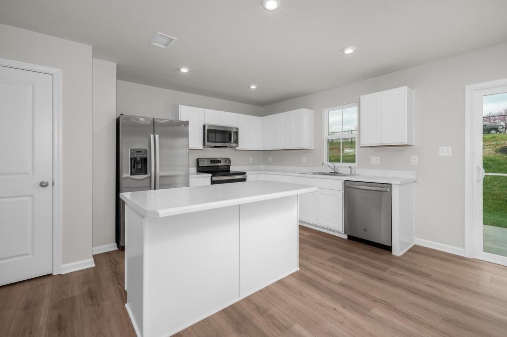 1110 Aubrey Meadows Place Franklin, KY 42134 - Photo 7 of 20 a kitchen with kitchen island a sink stainless steel appliances and cabinets