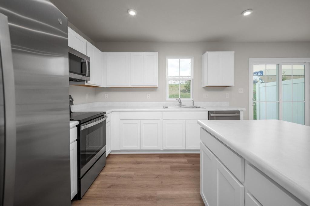 1110 Aubrey Meadows Place Franklin, KY 42134 - Photo 9 of 20 a kitchen with stainless steel appliances granite countertop a sink a stove a refrigerator and white cabinets