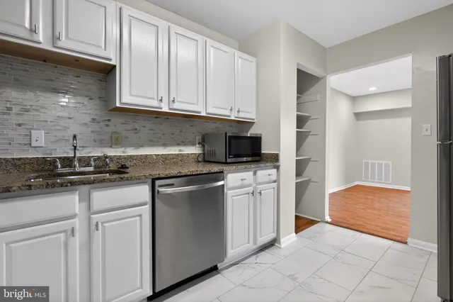 a kitchen with stainless steel appliances granite countertop a sink and a stove