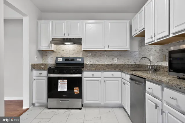 a kitchen with cabinets appliances and a sink