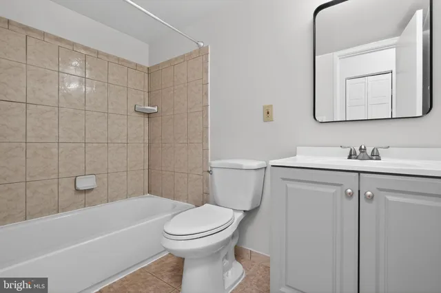 a bathroom with a toilet a sink a mirror and bathtub