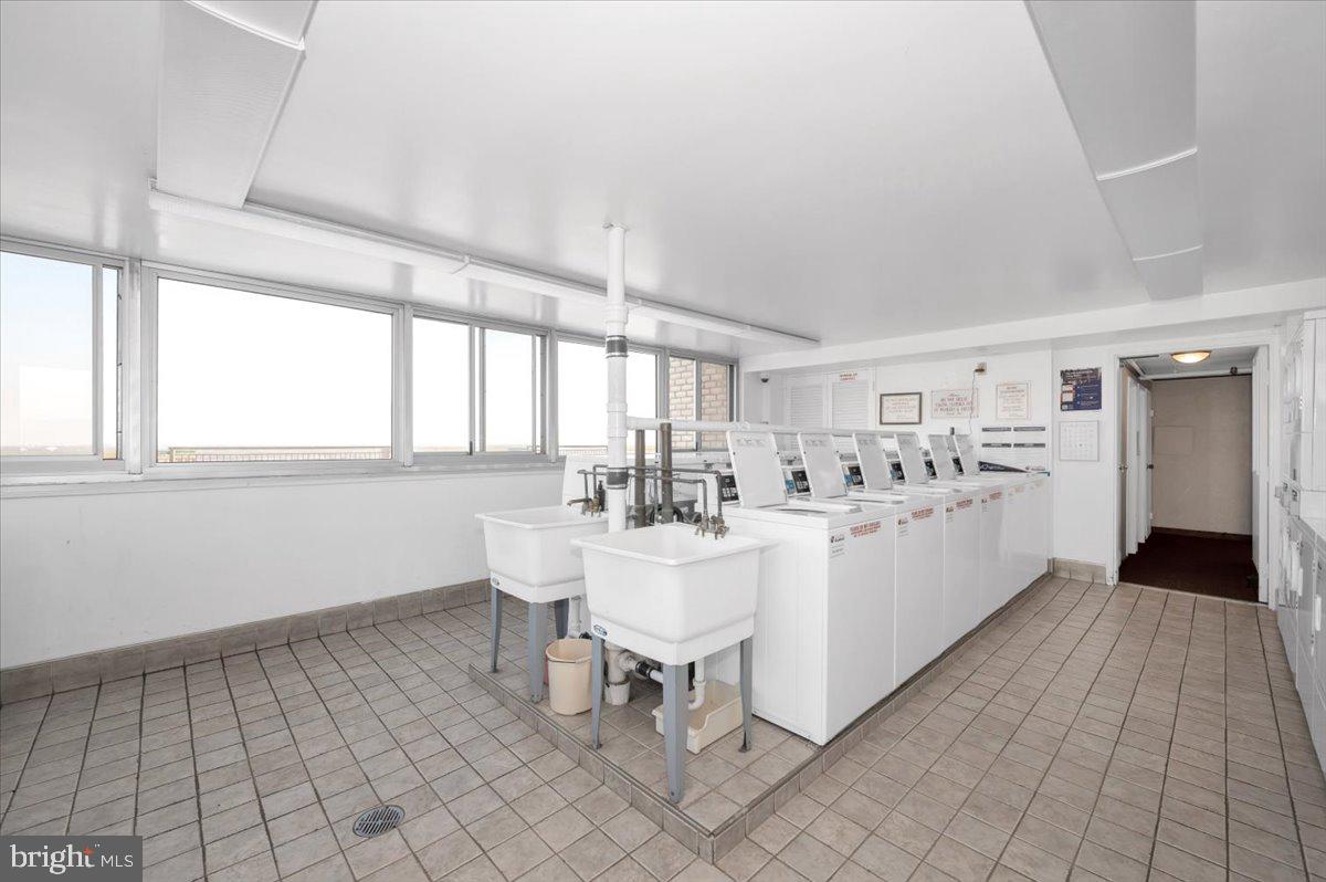 9701 Fields Road, Unit 2206 Gaithersburg, MD 20878 - Photo 23 of 30 a large white open kitchen with a white stove top oven and white cabinets next to a window