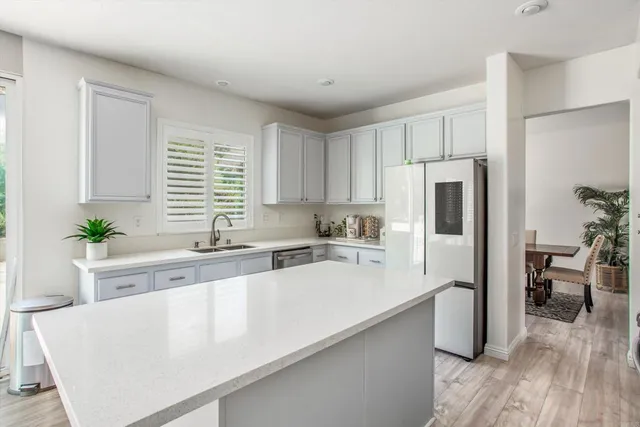 a kitchen with a refrigerator a sink and white cabinets