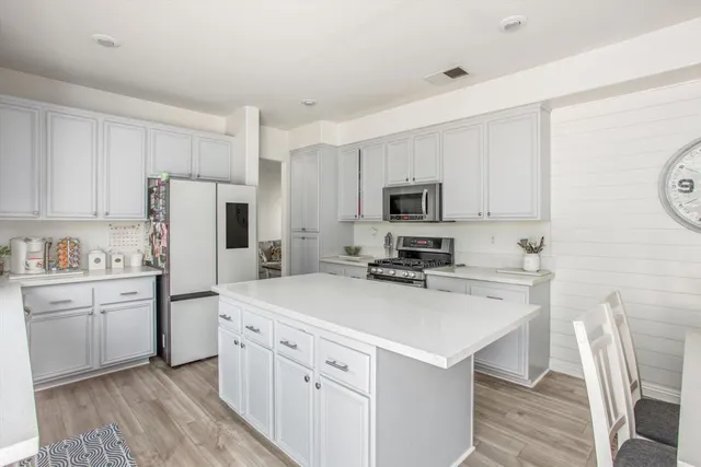 a kitchen with white cabinets and white appliances