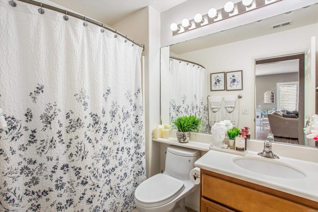 16478 Spirit Road Moreno Valley, CA 92555 - Photo 20 of 32 a bathroom with a sink a toilet a mirror and shower curtain