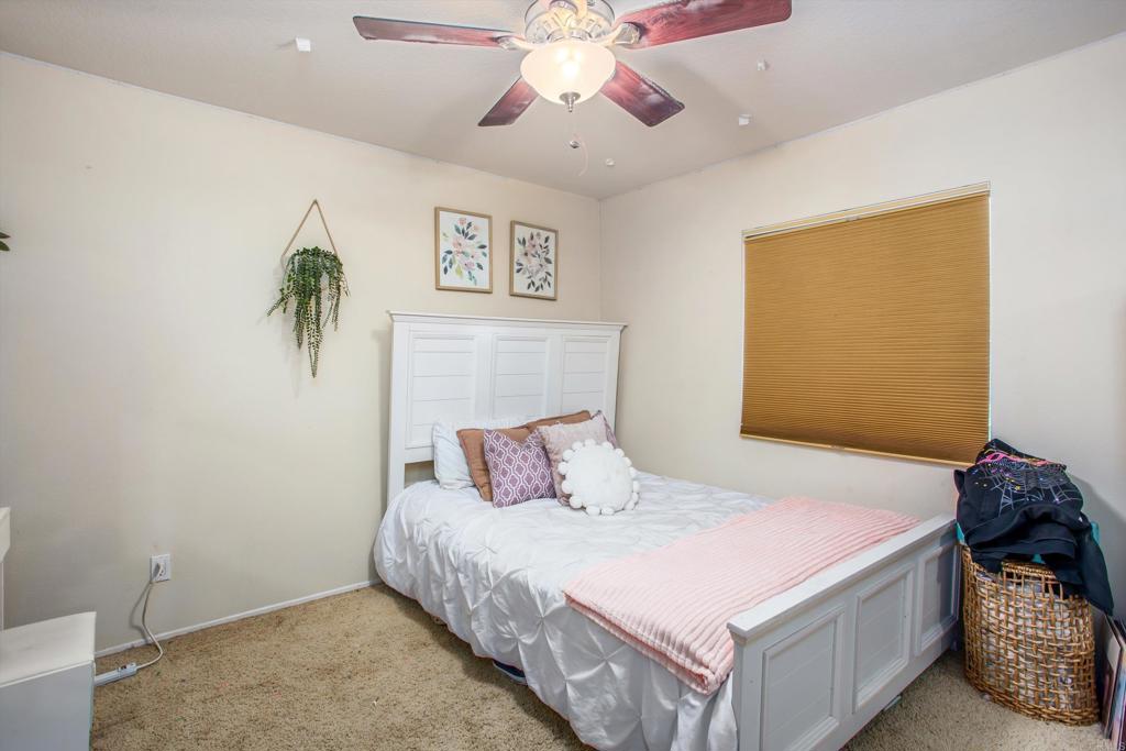 16478 Spirit Road Moreno Valley, CA 92555 - Photo 24 of 32 a bedroom with a bed and a chandelier