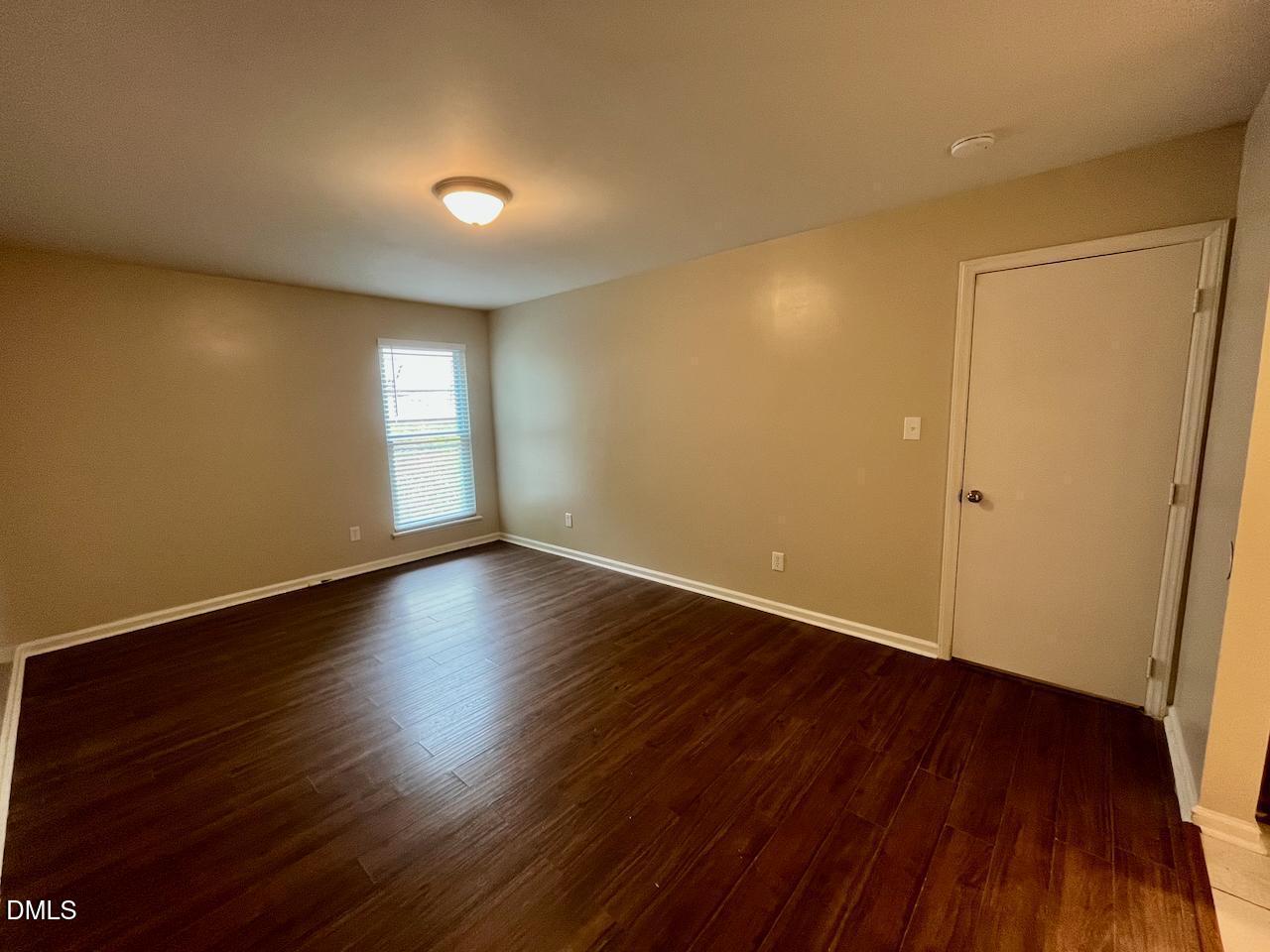 4205 Greencastle Court, Unit D Raleigh, NC 27604 - Photo 12 of 13 an empty room with wooden floor and windows