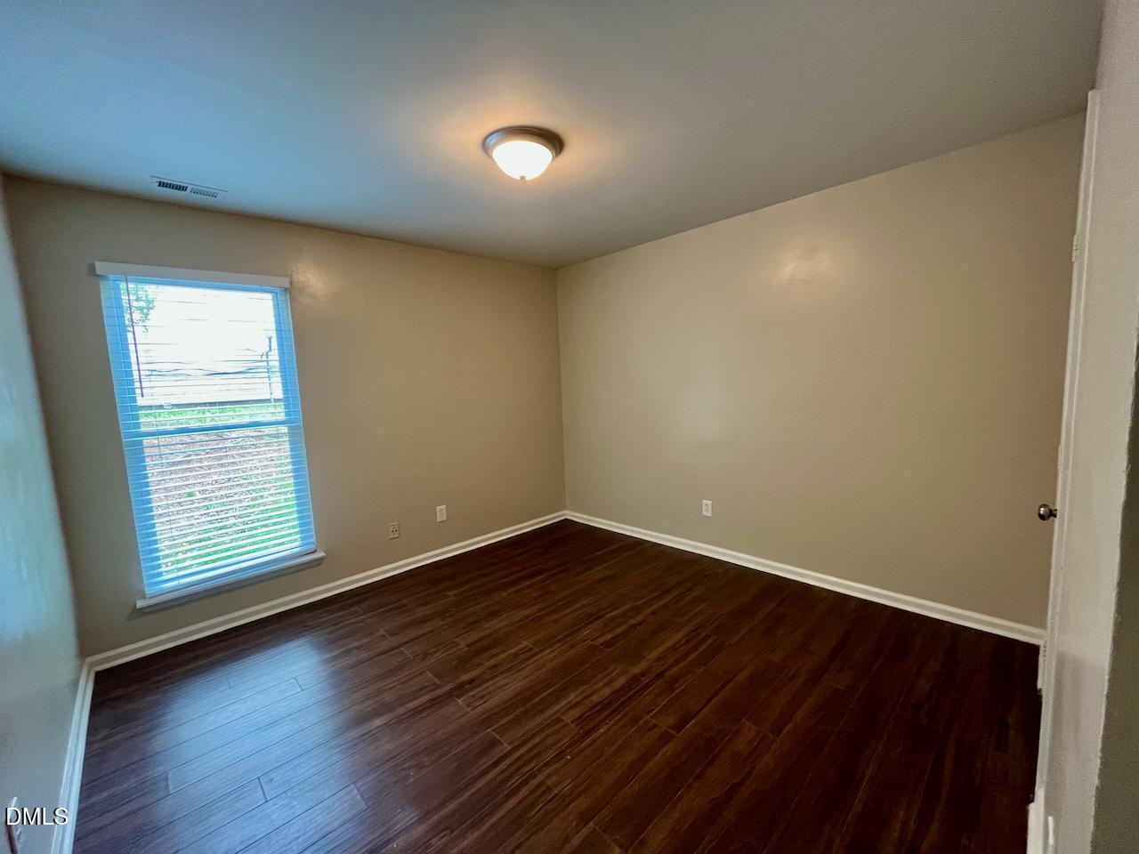 4205 Greencastle Court, Unit D Raleigh, NC 27604 - Photo 7 of 13 an empty room with wooden floor and windows