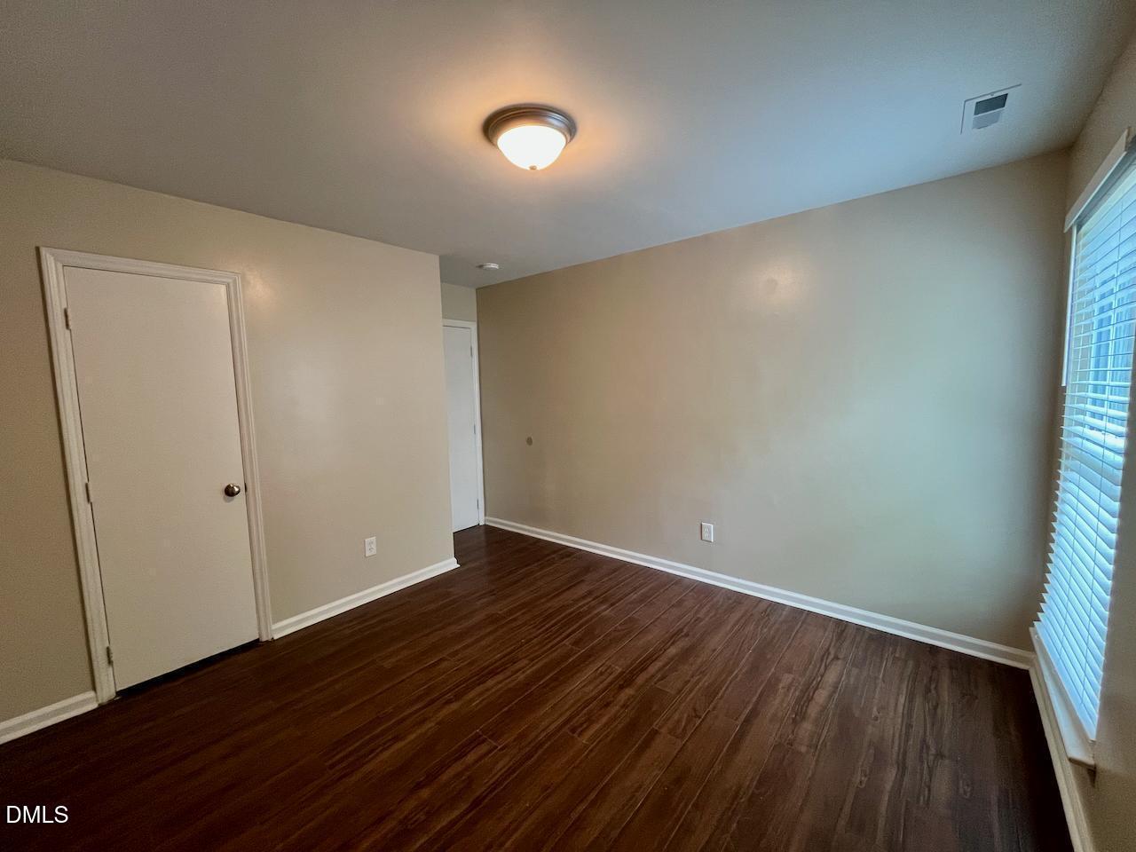 4205 Greencastle Court, Unit D Raleigh, NC 27604 - Photo 8 of 13 a view of an empty room with wooden floor and a window