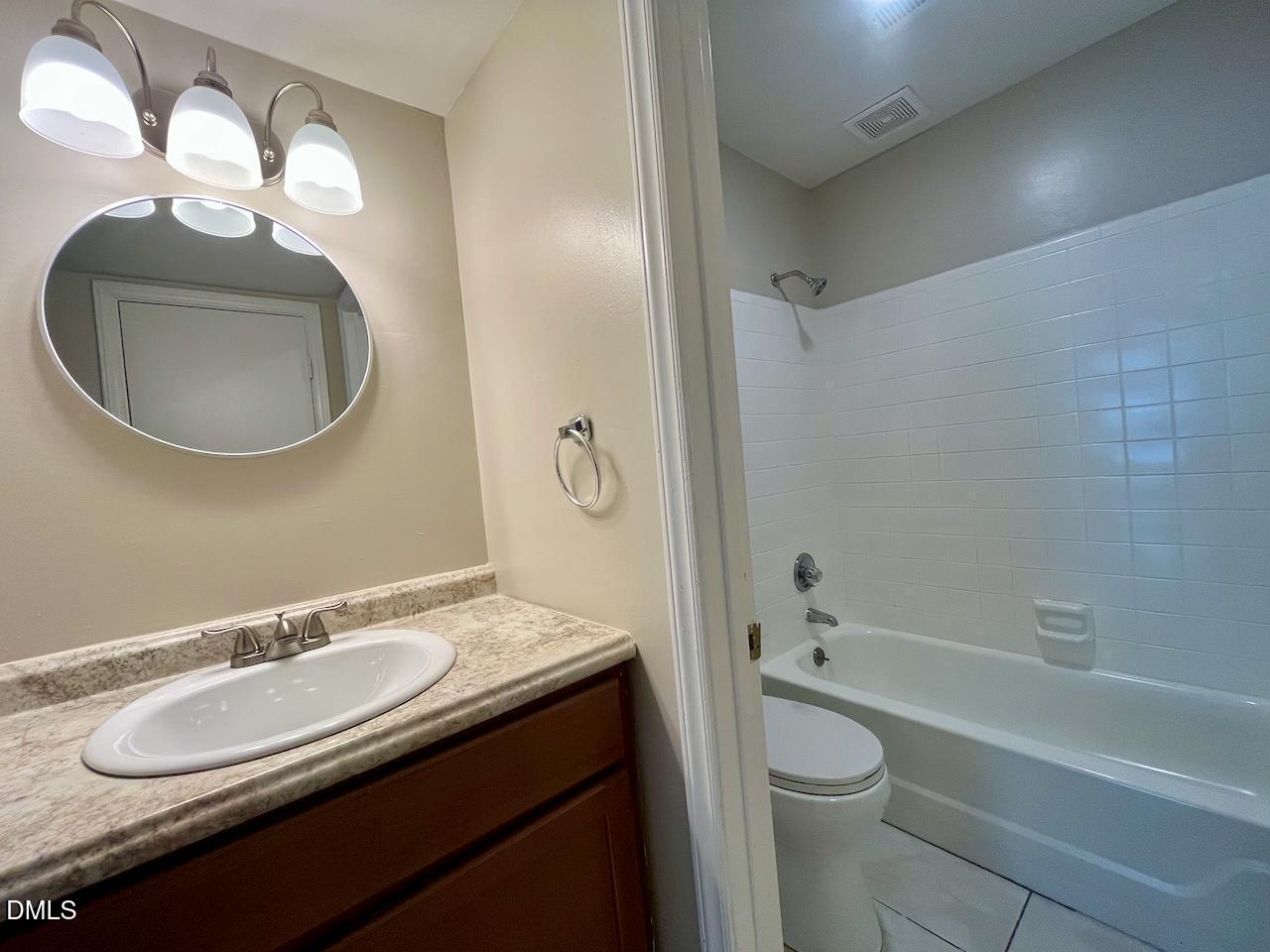 4205 Greencastle Court, Unit D Raleigh, NC 27604 - Photo 10 of 13 a bathroom with a granite countertop sink and a mirror