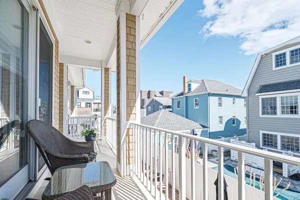 a view of a dining room with furniture a chandelier and large windows