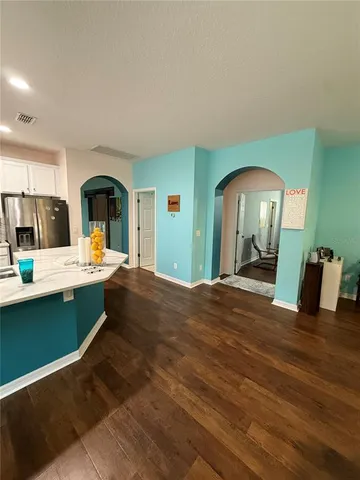 a view of kitchen dining table a sink and a refrigerator