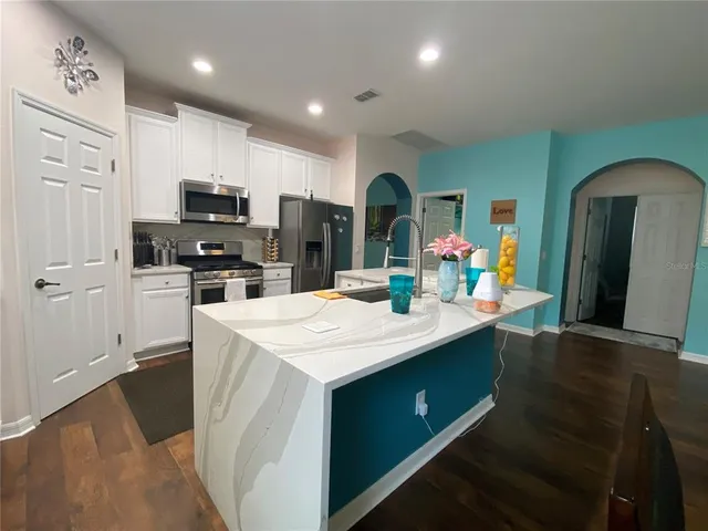a kitchen with kitchen island a sink stainless steel appliances and cabinets