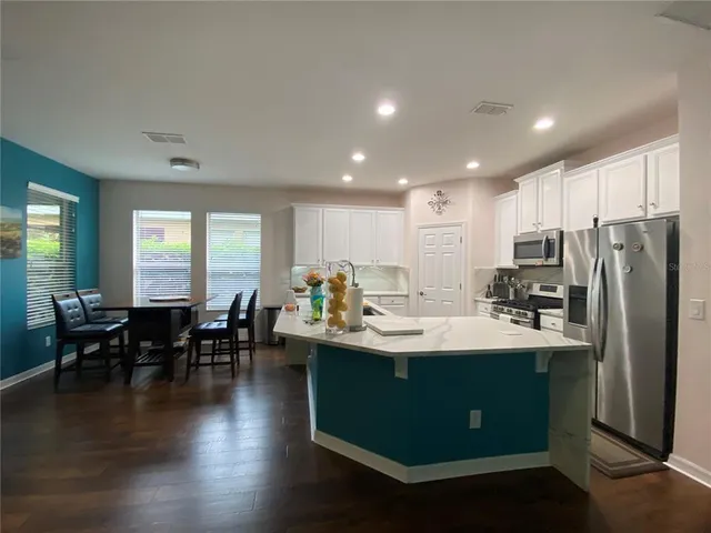 a kitchen with counter top space sink stainless steel appliances and dining table