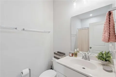 a bathroom with a sink mirror vanity and toilet