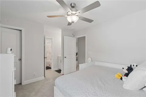 a spacious bedroom with a bed and ceiling fan
