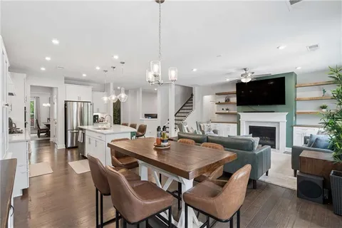 a view of a dining room and a kitchen with a table chairs and a fireplace