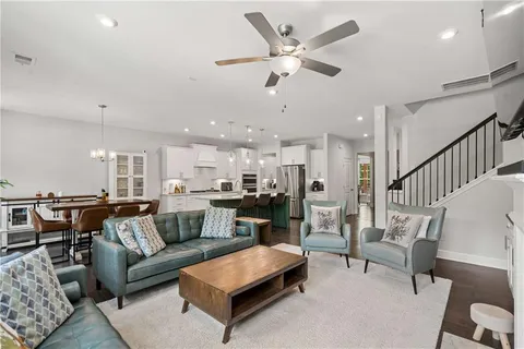 a living room with furniture kitchen view and a chandelier