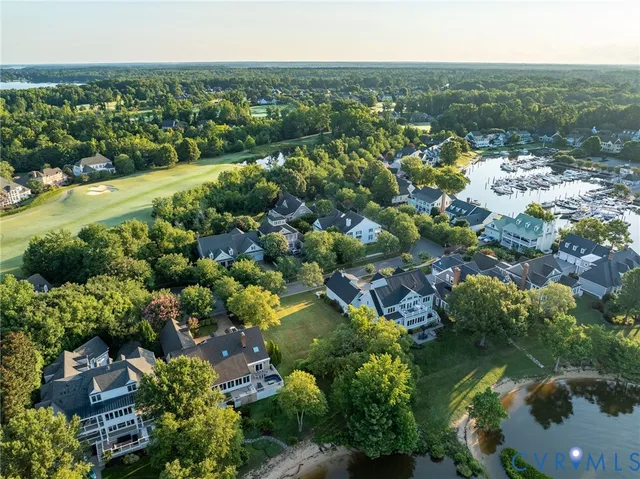 an aerial view of a residential houses with outdoor space and trees