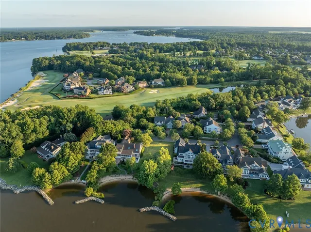 an aerial view of a houses with a yard and lake view