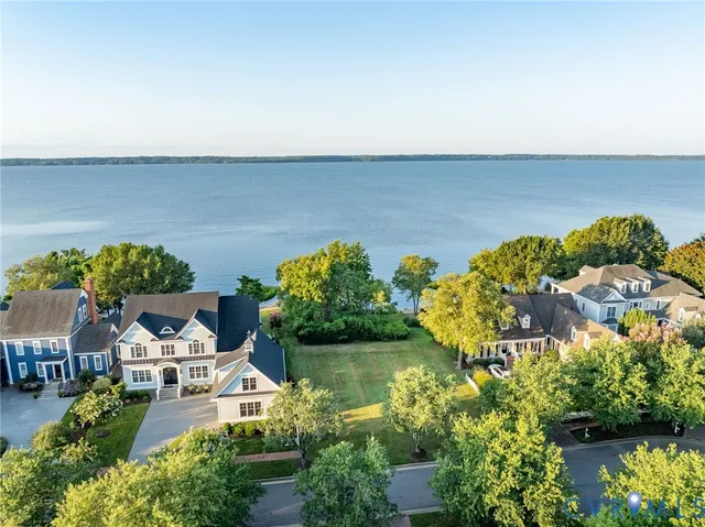 an aerial view of a house with a yard and lake view