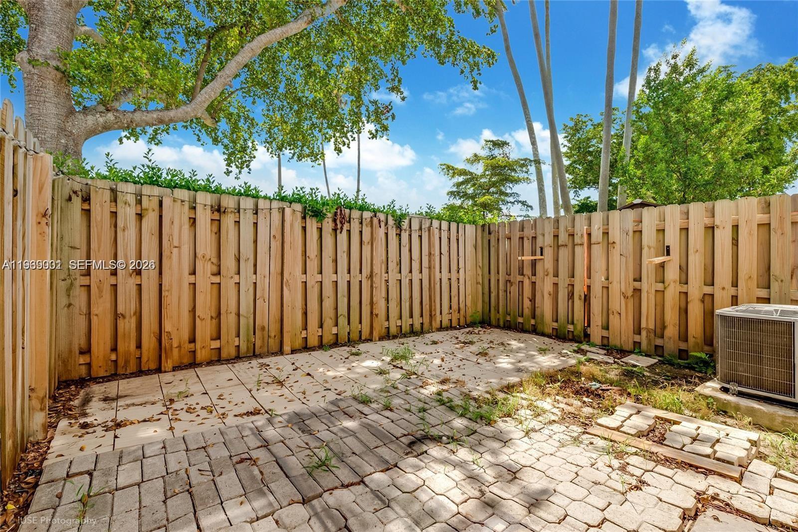 1705 Southeast 27th Street Homestead, FL 33035 - Photo 7 of 17 a view of backyard with wooden fence and trees