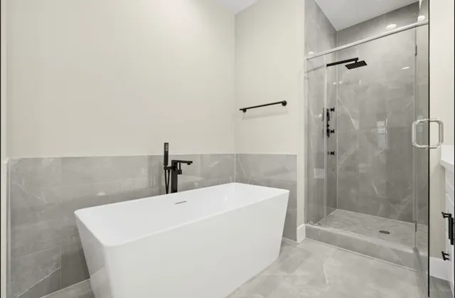 a white bath tub sitting next to a shower