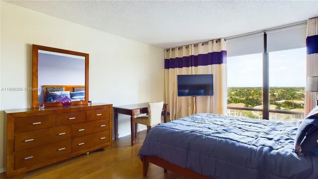 a bedroom with a bed and a dresser next to a window