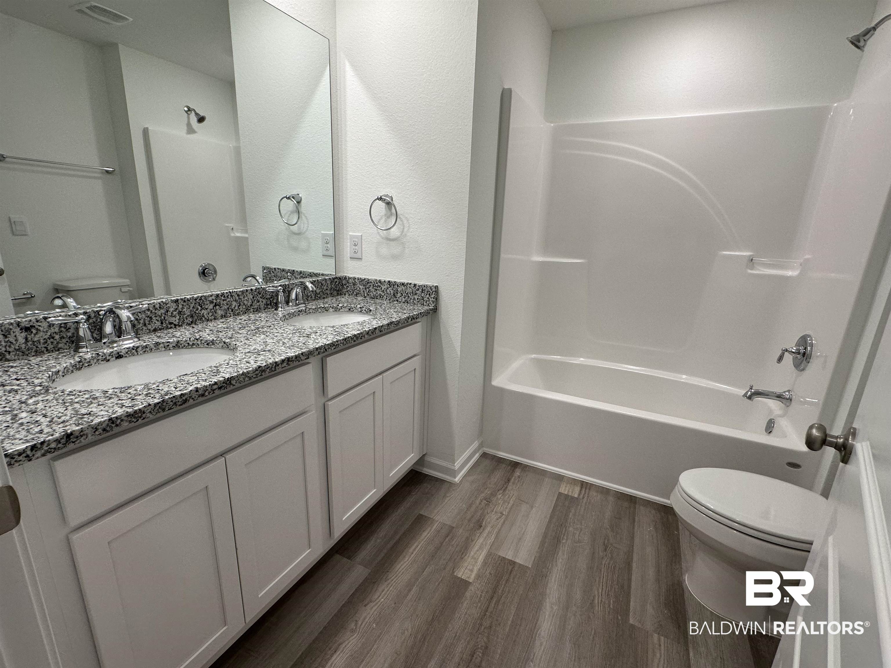 22275 Aleutian Avenue Foley, AL 36535 - Photo 25 of 72 Full bathroom with toilet, vanity, hardwood / wood-style floors, and shower combination