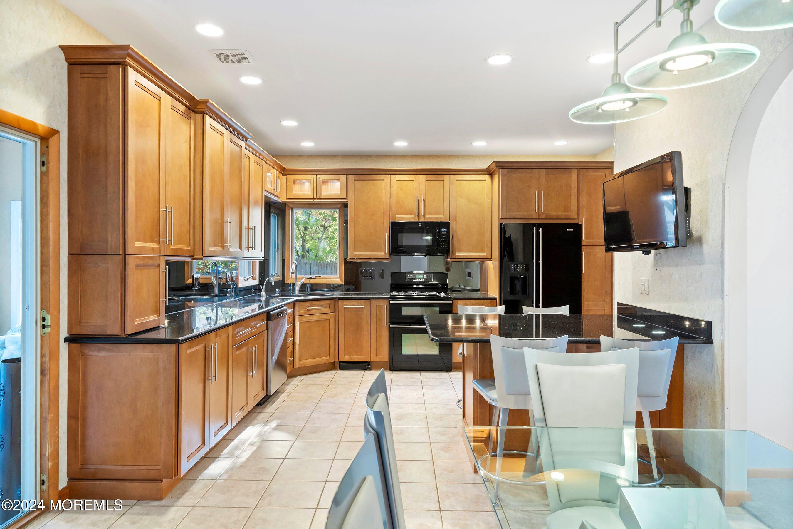 742 Rabbit Run Brick, NJ 08724 - Photo 17 of 51 a kitchen with stainless steel appliances granite countertop a stove top oven a sink dishwasher a dining table and chairs with wooden floor