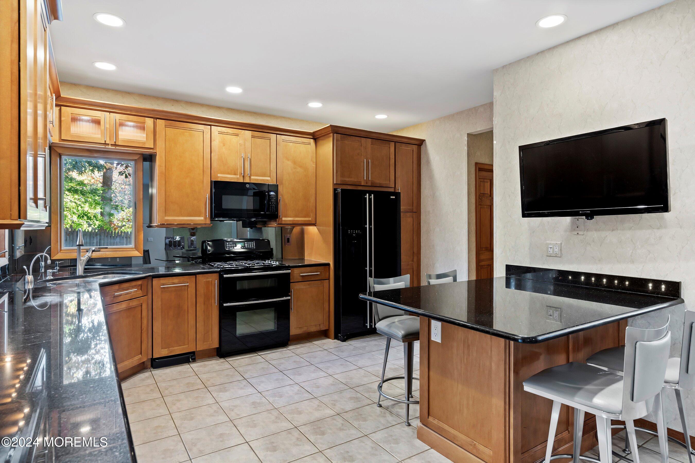 742 Rabbit Run Brick, NJ 08724 - Photo 19 of 51 a kitchen with stainless steel appliances granite countertop a stove a sink a microwave a refrigerator and cabinets