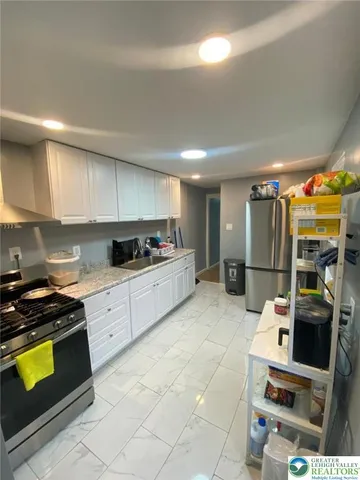 a kitchen with stainless steel appliances kitchen island granite countertop a stove and a refrigerator