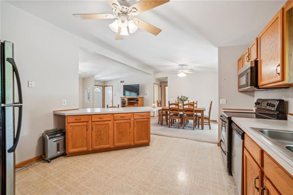 452 Upper Service Road Hookstown, PA 15050 - Photo 27 of 41 a large kitchen with stainless steel appliances granite countertop a refrigerator a sink dishwasher a dining table and chairs with wooden floor