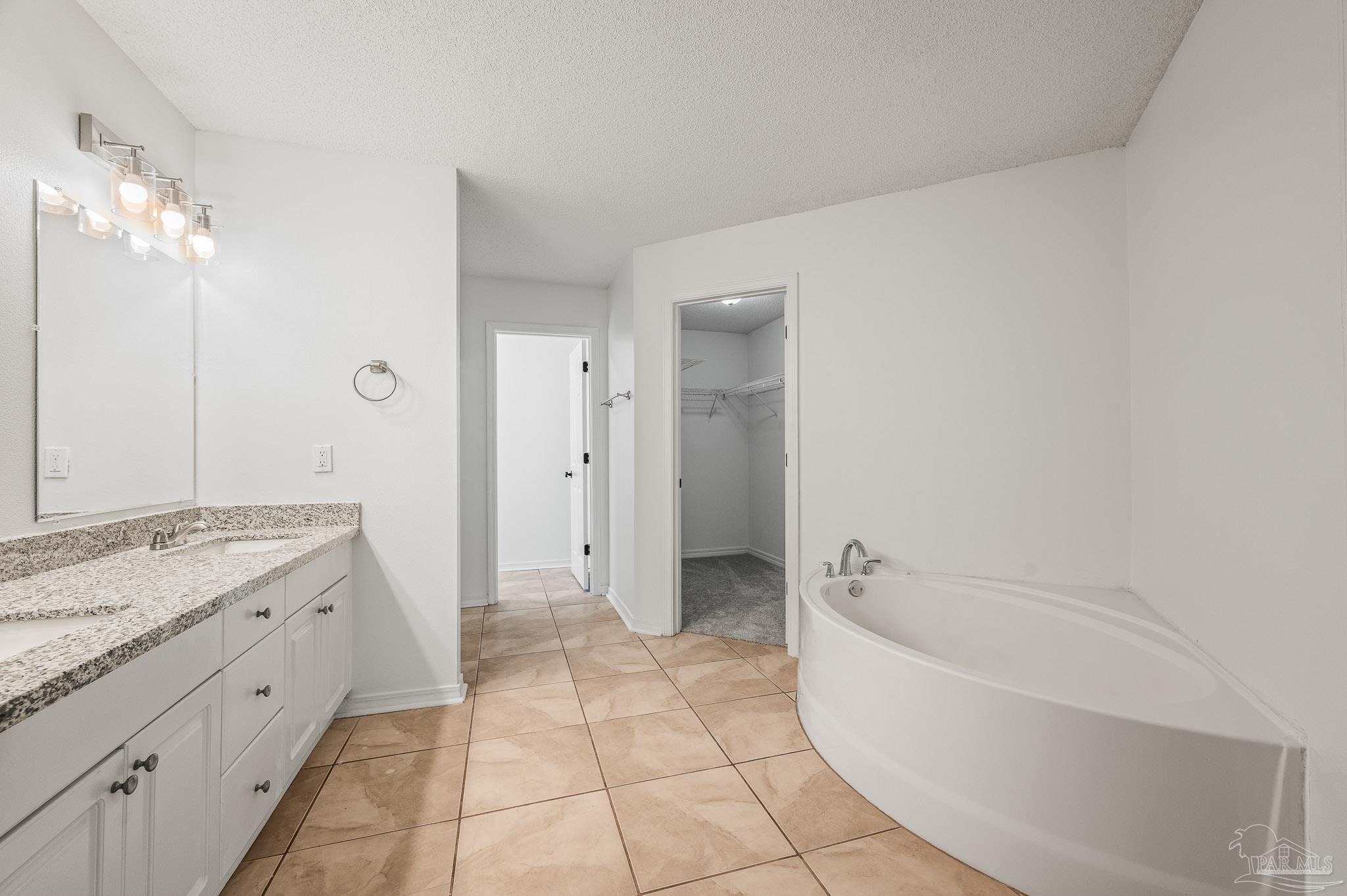 4263 Crosswind Drive Milton, FL 32583 - Photo 27 of 43 a bathroom with a granite countertop sink a toilet and bathtub