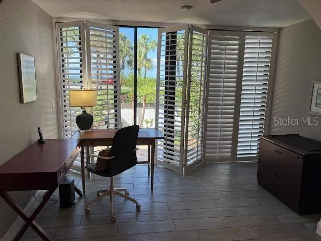 a view of a workspace with furniture and a window