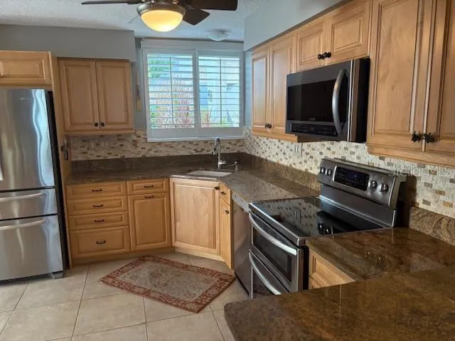 a kitchen with stainless steel appliances granite countertop a stove a microwave and a refrigerator