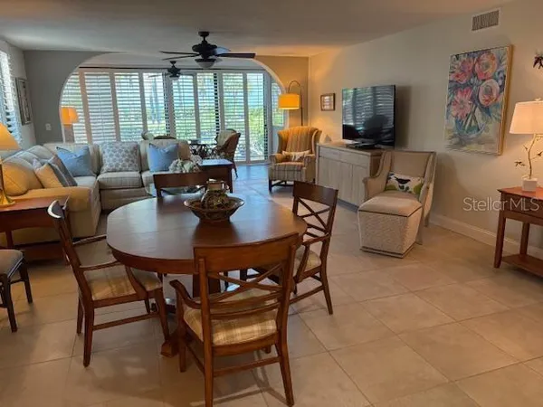 a dining room with furniture a flat screen tv and a large window