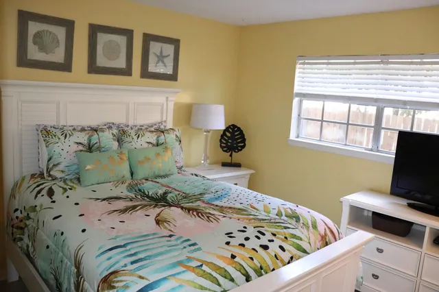 a bedroom with a bed and flat screen tv