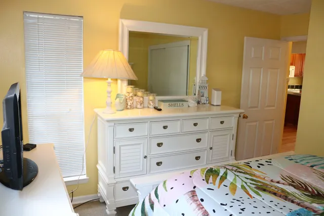a bedroom with a bed and a mirror on dresser