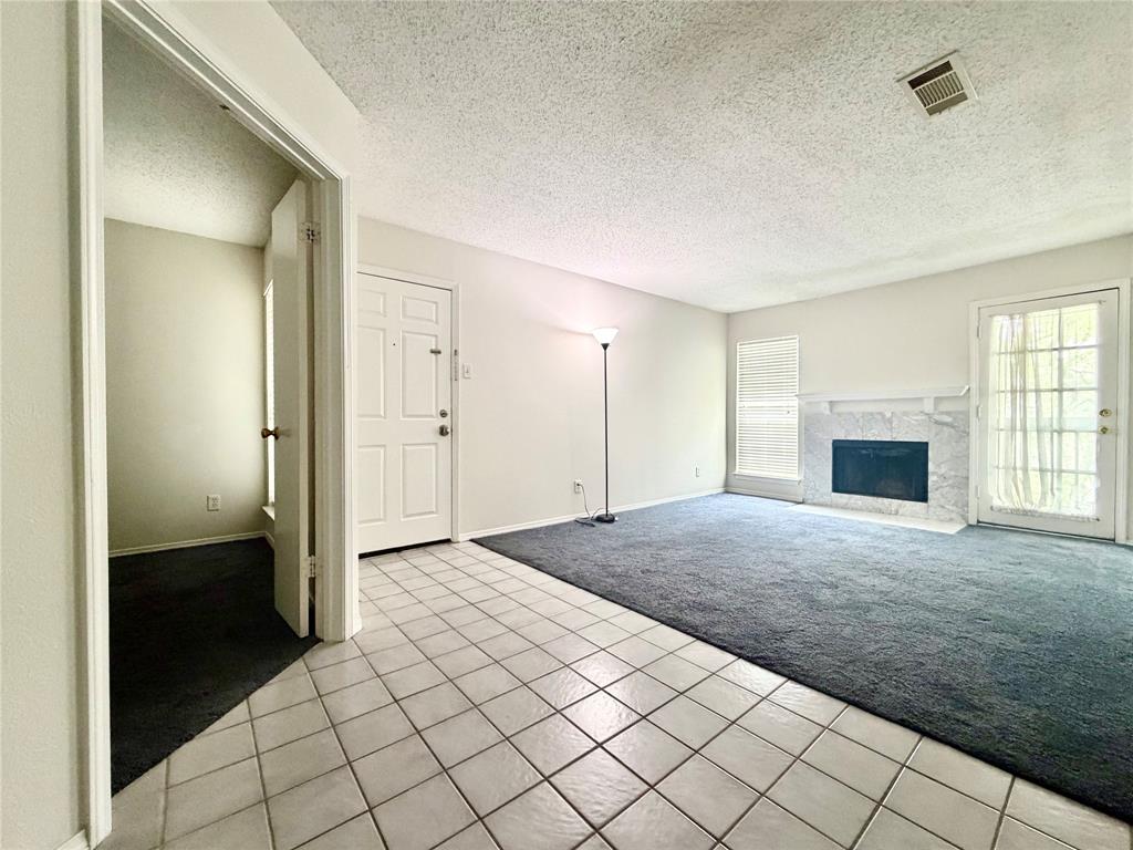 18333 Roehampton Drive, Unit 624 Dallas, TX 75252 - Photo 7 of 39 an empty room with windows and fireplace