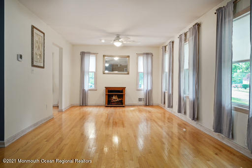 77 Tennent Road Morganville, NJ 07751 - Photo 3 of 37 a view of an empty room with a fireplace and a window