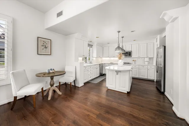 a kitchen with a sink and wooden floor