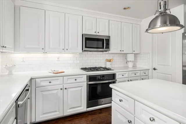 an empty room with wooden floor fireplace and windows