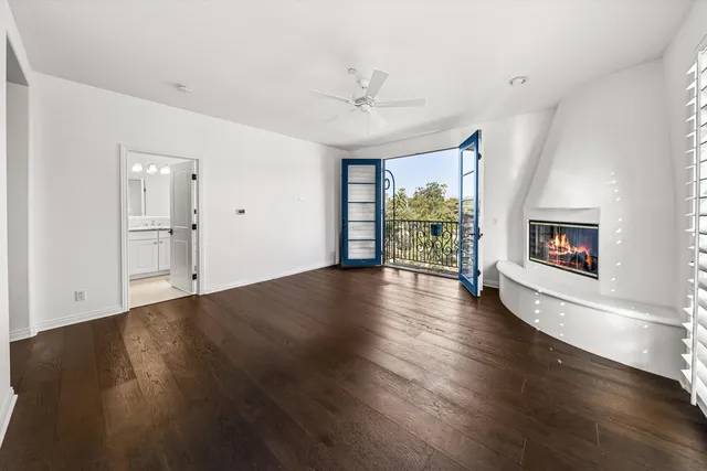 an empty room with cabinet wooden floors and a view of bathroom