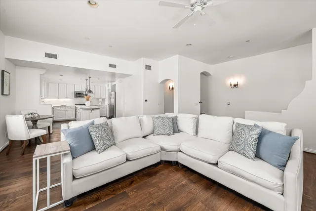 a kitchen with kitchen island granite countertop white cabinets white stainless steel appliances with a sink and dishwasher